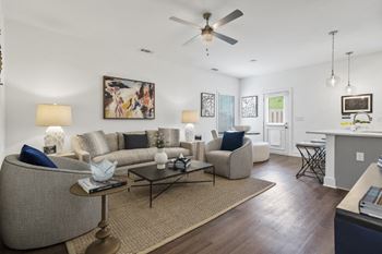 An open floor plan with wood-plank floors and ceiling fan.